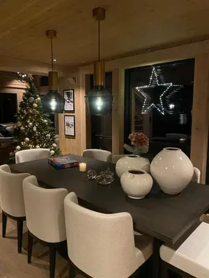 a dining room with a table and a christmas tree at Exclusive cottage on Geilo in Hol
