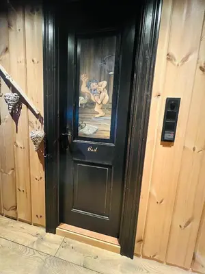 a black door with a picture on it at Cabin in Kvamskogen in Kvam