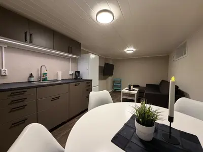 a kitchen and living room with a table and a couch at Ny leilighet i Stjørdal in Stjoerdal