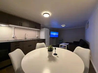 a room with a table and chairs and a kitchen at Ny leilighet i Stjørdal in Stjoerdal