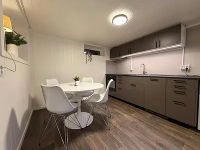 a kitchen with a white table and white chairs at Ny leilighet i Stjørdal in Stjoerdal