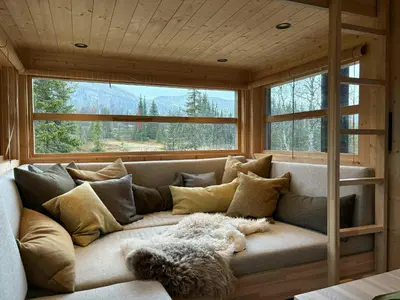 a large couch in a room with windows at Ål Cabin With Views Of Marshland And Mountains in Flå