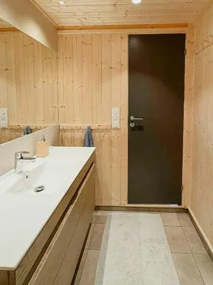 a bathroom with a sink and a black door at Ål Cabin With Views Of Marshland And Mountains in Flå