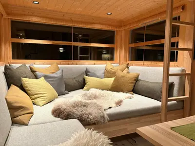 a couch with pillows and a dog laying on it at Ål Cabin With Views Of Marshland And Mountains in Flå