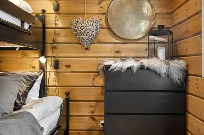 a room with a wooden wall with a bed and a clock at Trysilfjell hytteområde 922 by Vacation Trysil in Trysil
