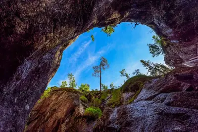 a hole in the rock with a tree in the background at Modern cabin with panoramic view, sauna and fire pit in Espedalen