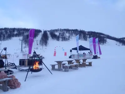 a picnic table and a fire in the snow at Skarslia Apartment in Skarsgård