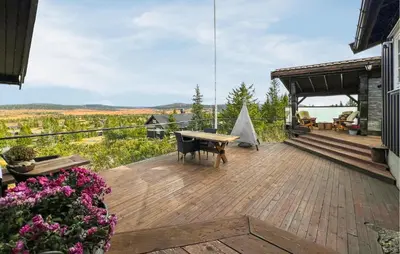 a wooden deck with a table and bench on a house at Amazing Home In Sjusjøen With Sauna in Sjusjøen
