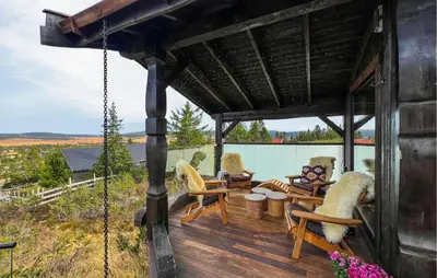 a wooden porch with chairs and a swing at Amazing Home In Sjusjøen With Sauna in Sjusjøen