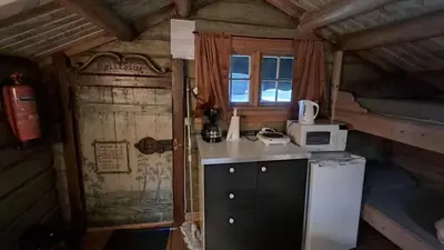 a small kitchen with a refrigerator and a microwave at Ringen Camping in Vestre Gausdal