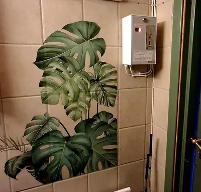a bathroom with a mural of a plant on the wall at Ringen Camping in Vestre Gausdal