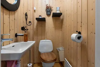a wooden bathroom with a toilet and a sink at Fageråsen 209 by Vacation Trysil in Trysil