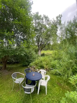 a table and chairs sitting in the grass at Cosy farmhouse with spa as add on service in Gjøvik