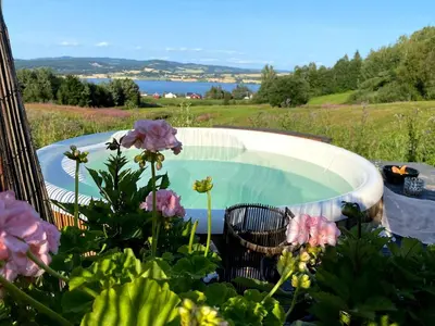 a swimming pool in a garden with flowers at Cosy farmhouse with spa as add on service in Gjøvik