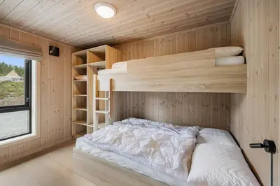 a bedroom with a bed in a wooden room at Sentralt plassert hytte, alt i gangavstand in Flå
