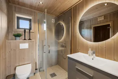 a bathroom with a shower and a toilet and a sink at Sentralt plassert hytte, alt i gangavstand in Flå