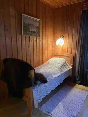 a bedroom with a bed in a wooden room at Det vesle huset på Lysåker in Nord-Fron