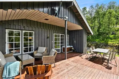 a patio with chairs and a table on a wooden deck at Filefjellhytta ved Tyin og Jotunheimen Ski in og ski out til alpinanlegg og skiløyper in Tyinkrysset