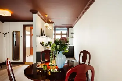 a dining room table with a vase of flowers on it at Bryggen Boutique l Stay Uniquely l 2 min to Floyen in Bergen