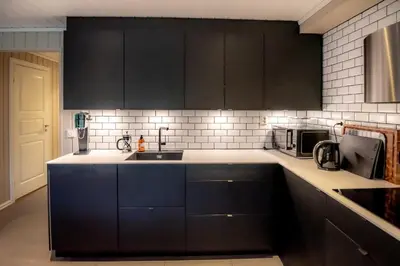 a kitchen with black cabinets and a sink at Trysilfjellet Nord 985A in Trysil