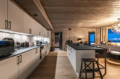 a large kitchen with white cabinets and a table at Brand new luxury apartment by the slopes, Hemsedal in Hemsedal