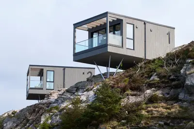 a house on the side of a mountain at Hideaway Herdla luxurious cabins 15 m above the sea in Herlø