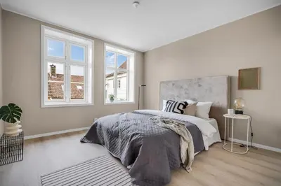 a bedroom with a large bed and two windows at Beautiful 3 room apartment centrally located in Sandviken in Bergen