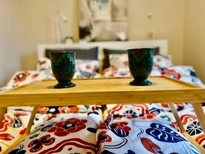 two green vases sitting on a table in front of a bed at Riverside family-friendly Mini Penthouse in Trondheim