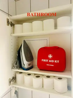 a red first aid kit on a shelf in a bathroom at Riverside family-friendly Mini Penthouse in Trondheim