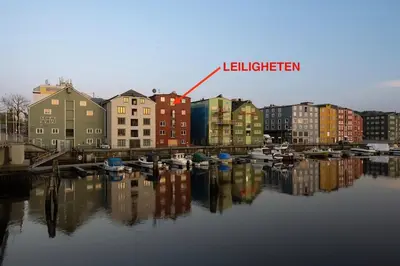 a city with buildings and boats in the water at Riverside family-friendly Mini Penthouse in Trondheim