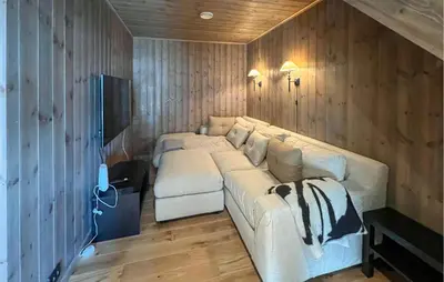 a living room with a white couch in a room with wooden walls at Stunning Home In Noresund With Sauna in Noresund