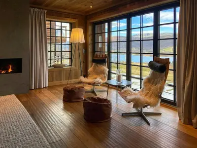 a living room with two chairs and a fireplace at Flat With Panoramic Views Of Hallingskarvet in Geilo