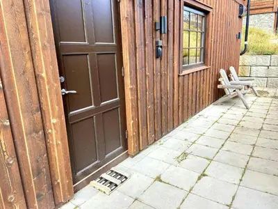 a door to a house with a chair next to it at Flat With Panoramic Views Of Hallingskarvet in Geilo