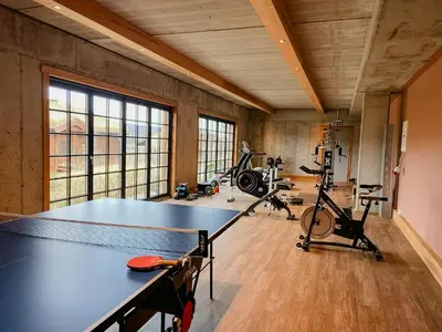a gym with a ping pong table and exercise bikes at Flat With Panoramic Views Of Hallingskarvet in Geilo