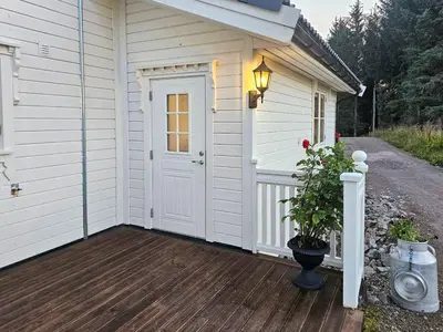 a white garage with a door on a wooden deck at Charming Farm Stay On Averøy Island in Averoy