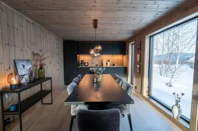 a dining room with a table and a large window at Cozy Family Cabin Ski centre, shuttle bus in Noresund