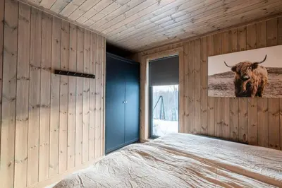 a bedroom with a large bed with a painting of a bull at Cozy Family Cabin Ski centre, shuttle bus in Noresund
