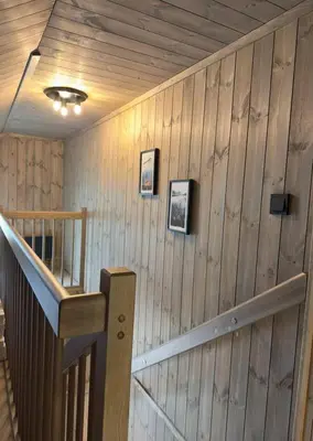 a wooden wall with a staircase in a room at Cozy Family Cabin Ski centre, shuttle bus in Noresund
