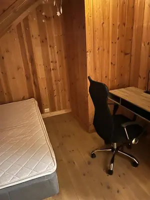 a room with a bed and a desk and a chair at Fengselet Gjestegård in Leira
