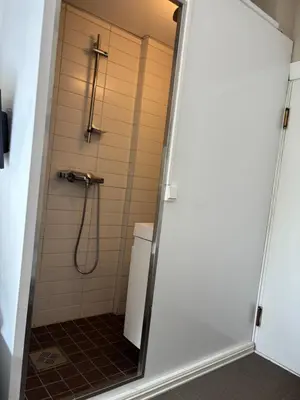 a shower in a bathroom with a glass door at Fengselet Gjestegård in Leira