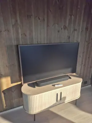 a large flat screen tv on a wooden wall at Modern mountain cabin with panorama view in Eggedal