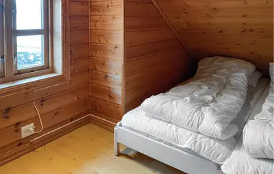 a small room with a bed in a log cabin at 4 Bedroom Lovely Home In Leinøya in Fosnavåg