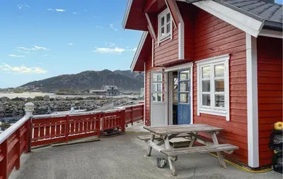 a red house with a picnic table in front of it at 4 Bedroom Lovely Home In Leinøya in Fosnavåg