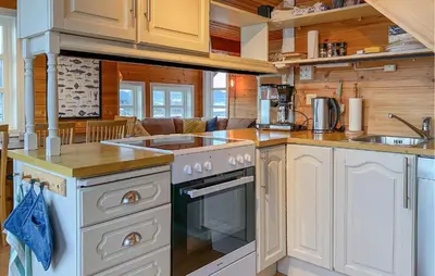 a kitchen with white cabinets and a stove top oven at 4 Bedroom Lovely Home In Leinøya in Fosnavåg