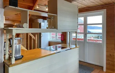 a kitchen with wooden walls and a counter top at 4 Bedroom Lovely Home In Leinøya in Fosnavåg