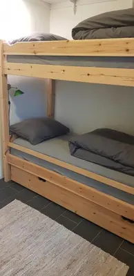two wooden bunk beds in a room with a rug at Et golfslag fra Stiklestad Golfklubb in Verdal