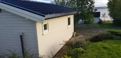 a small white building with a blue roof at Et golfslag fra Stiklestad Golfklubb in Verdal