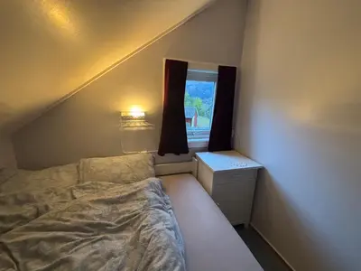 a small bedroom with a bed and a window at Jåstad Gjestetun in Jåstad