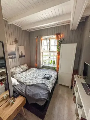 a small bedroom with a bed and a window at Modern and spacious home in Trondheim