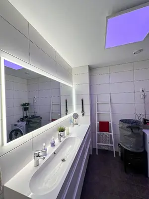 a bathroom with a sink and a large mirror at Modern and spacious home in Trondheim